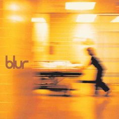 blurry photograph of a person walking in front of a building with the word bur on it