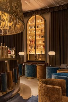 a fancy bar with blue velvet chairs and gold accents