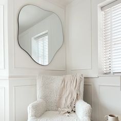 a white chair and mirror in a room