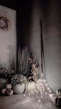 a bunch of pumpkins sitting on the ground in front of a door with lights