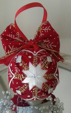 a red and white ornament with a bow on it