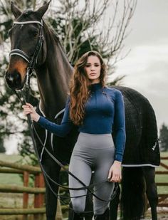 a woman is standing next to a horse