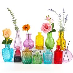 there are many different colored vases with flowers in them