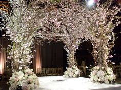 an archway decorated with white flowers and greenery for a wedding ceremony at the ritz