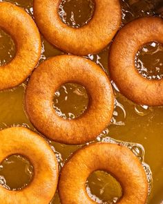 several doughnuts sitting in oil on top of a pan