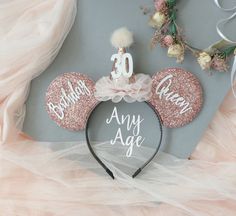 a minnie mouse ears headband with the number 20 on it and pink glitters