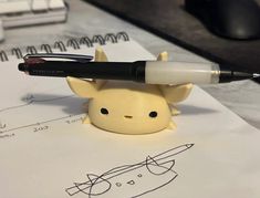 a small toy with a pen on top of it