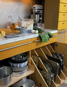 an organized kitchen with pots, pans and other items in the cabinet drawer area