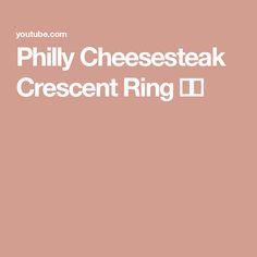 the words phily cheesesteak crescent ring in white font on a pink background