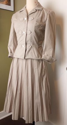 I believe this skirt set was hand tailored in the 1970's to look like a 1940's style. This fabric feels to be a cotton polyester blend.  Jacket:    Shoulders: 15"    Bust: 17"    Waist: 13.5"    Hem width: 16"    Length: 19.5"    Sleeve length: 16.5"     Skirt:    Waist: 12"    Hip: 18"    Hem width: 41"    Length: 27"     These are garment measurements taken flat not of the body that will fit into it. Please note this fabric has no stretch, leave room to move. Click the heart to receive a 10% off coupon code New items added weekly Happy to answer your questions Pirate Dress, 1940's Style, Outfit References, Tan Jacket, Fitted Suit, Style Skirt, Work Outfits Women