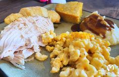 a plate with macaroni and cheese, turkey breast, cornbreads and gravy