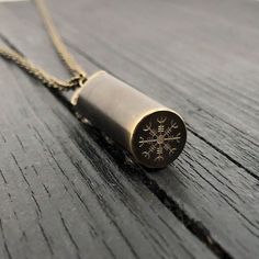 a necklace with a snowflake on it sitting on top of a wooden table