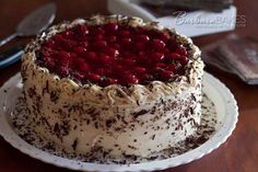 a cake with white frosting and chocolate sprinkles is on a plate