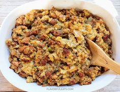 a white bowl filled with stuffing and a wooden spoon