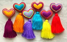 colorful hearts and tassels are arranged on a marble surface with one heart in the middle