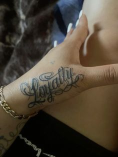 a woman's hand with the word happily tattooed on her left arm and wrist