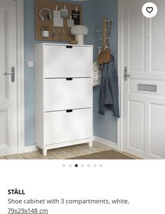 a white cabinet with 3 compartments in the middle and coat rack on top next to it