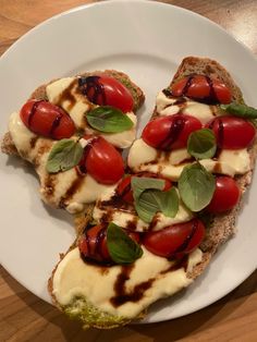 three slices of bread with tomatoes and mozzarella on them sitting on a white plate