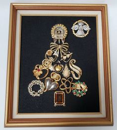 a framed christmas tree made out of assorted brooches and other jewelry items