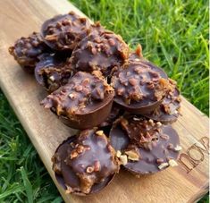 chocolate covered cookies sitting on top of a wooden cutting board