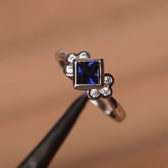 It is a lab blue sapphire ring. The main stone is 5mm*5mm square cut, weight about 0.74carats. The basic metal is sterling silver and plated with rhodium. To change the metal to a solid gold (white/rose) or platinum is also available, please ask for a quotation if you want. lab sapphire is the birthstone of September. You can also go to my shop Home for more elegant rings: https://www.etsy.com/shop/godjewelry?ref=hdr_shop_menu More rings: https://www.etsy.com/shop/godjewelry?ref=l2-shop-header-a Peridot Birthstone Ring, Square Cut Engagement Rings, Square Cut Rings, Sapphire Promise Rings, September Birthstone Ring, Ring Princess Cut, Peridot Engagement Rings, Elegant Rings, Square Engagement Rings