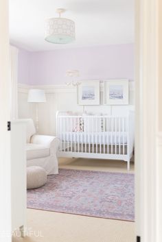 a baby's room with a white crib and pink walls