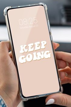 a woman holding an iphone case with the words keep going on it in front of her