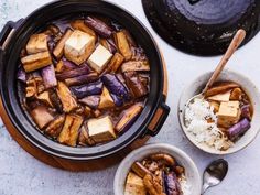 two bowls filled with tofu and rice next to an old fashioned crock pot