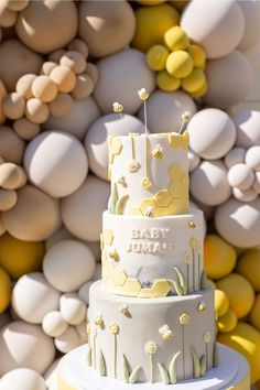 a three tiered cake sitting on top of a table next to white and yellow balls