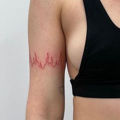 a woman's arm with a red flame tattoo on the left side of her body