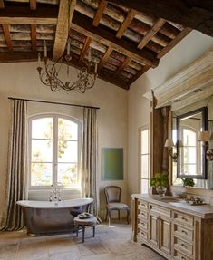 a bathroom with a claw foot tub and chandelier hanging from it's ceiling