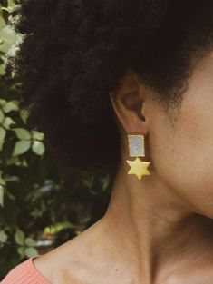 Be the star of the show with these festive statement earrings! A six-pointed star hangs from a glittery natural druzy gemstone for a fun, dramatic effect. Approximate measurements: 0.5" wide x 1.75" long Pure brass plated with 24 kt gold Stone colors and shapes may vary slightly from what's shown. Handmade in India in an ethical and fair wage production facility. Ash & Rose exclusive design Sparkling Star-shaped Jewelry For Parties, Elegant Glitter Dangle Jewelry, Star Charm Jewelry For Parties, Star Shaped Glitter Earrings For Party, Party Jewelry With Star Charm, Star Shaped Party Jewelry With Star Charm, Party Drop Earrings With Star Charm, Glitter Jewelry For Gifts, Glitter Jewelry Gift