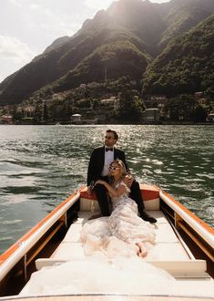 a bride and groom sitting on the back of a boat