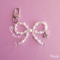 a keychain with beads and charms attached to it on a purple surface,