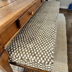 a wooden bench sitting next to a table on top of a rug