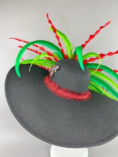 Black floppy hat with center red rose and feathers. Adorned with the jeweled bee, my signature mark. Hat fits crown size 22.5” and smaller with an internal elastic band for size adjustment. Please measure accordingly as all sales are final. Adjustable Hats For Kentucky Derby And Carnival, Adjustable Wide Brim Hat For Carnival, Fun Red Wide Brim Hat, Red Adjustable Hat With Structured Crown, Playful Red Spring Hat, Elegant Red Brimmed Hat, Red Spring Hat Headpiece, Black Floppy Hat, Derby Hats Fascinators