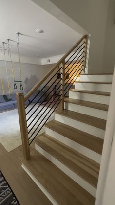 there is a stair case in the living room with swings on the wall and carpeted floor