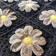 a crocheted blanket with white and yellow flowers