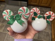 two christmas ornaments in the shape of candy canes with bows and glitter on them