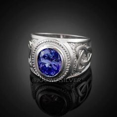 a ring with a blue stone in the center and diamonds around it on a black background