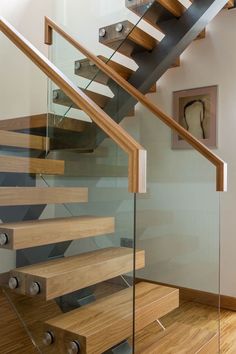 a stair case with glass railing and wood treadming on the bottom part of it