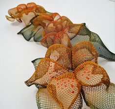 several small mesh bags are lined up on a table with orange and green netting around them