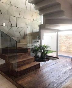 an indoor stair case with glass railing and wooden steps