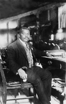 a black and white photo of a man sitting in a chair