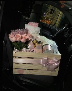 a wooden crate filled with pink roses in the back seat of a car at night