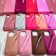 there are many different colored cases on the table with one pen in each cell phone case