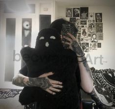 a person with tattoos holding a stuffed animal