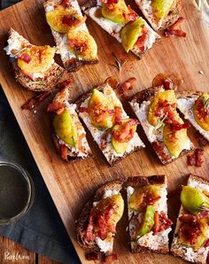 several pieces of bread with different toppings on them sitting on a wooden cutting board