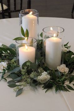 some candles are sitting on a table with flowers