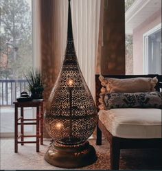 a large vase sitting on top of a table next to a window